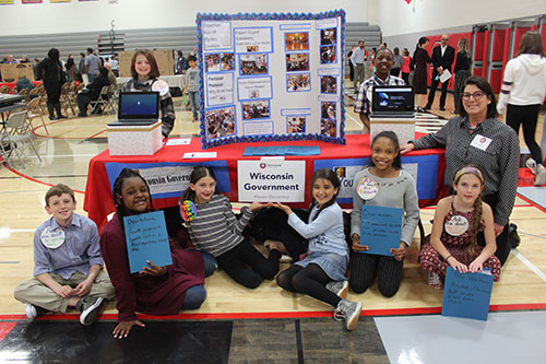 Mrs Cryns and some of her  4th grade students displaying their Wisconsin Government authentic learning project.