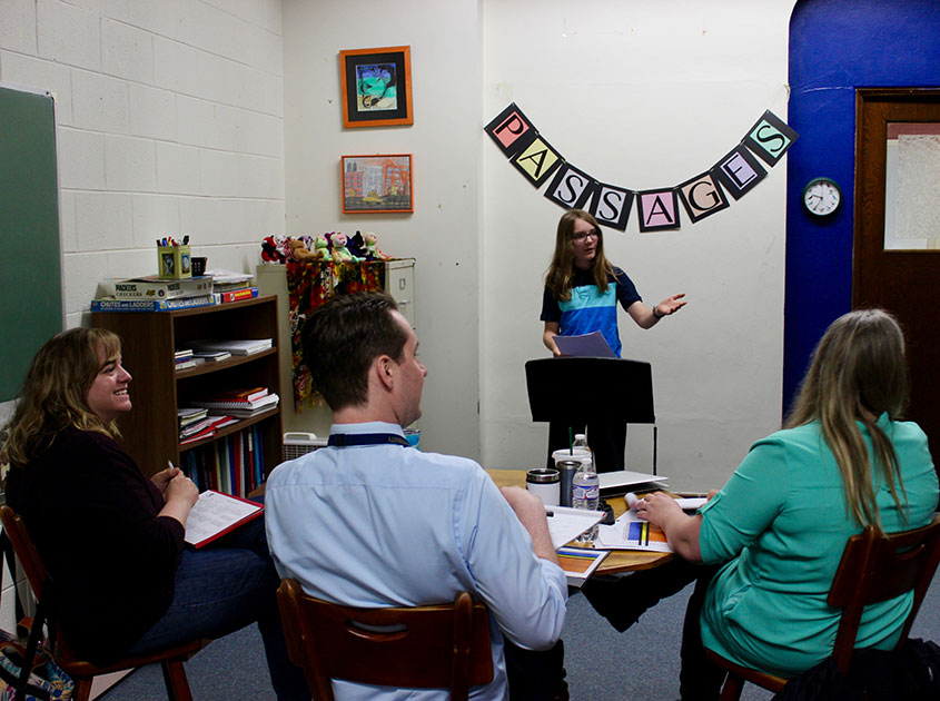 A former Atwater 6th grader giving a Passages presentation to Nate Schultz and two community members.